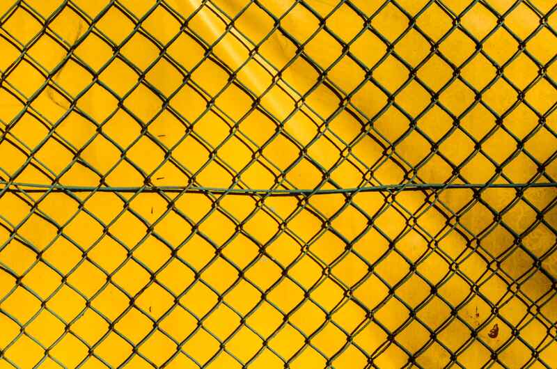 Chain-link fence covered with yellow privacy screen