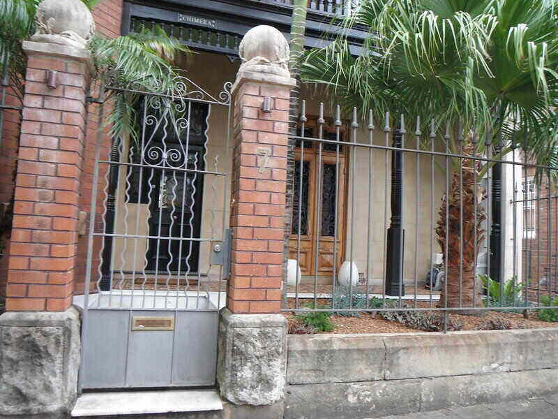 Iron fence and gate set between brick pillars